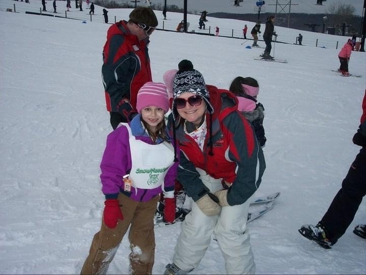 Emily Johnson teaching a student how to ski